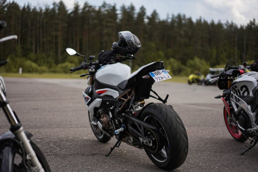 Een motorrijder die zijn motorrijbewijs A behaalt in een rijschoolomgeving, met een instructeur en motorfiets.